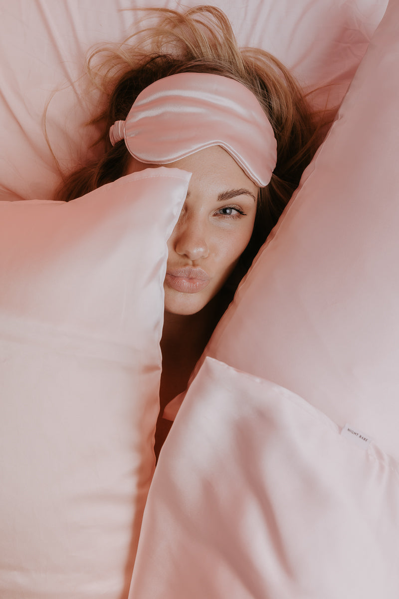 model with blush pink silk pillowcase